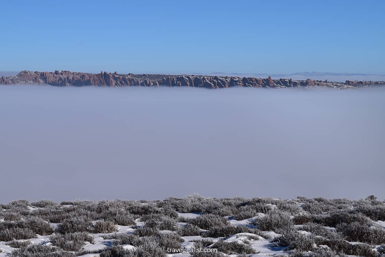 Salt Valley Overlook in winter almost entirely covered in fog in Arches National Park, Utah, US
