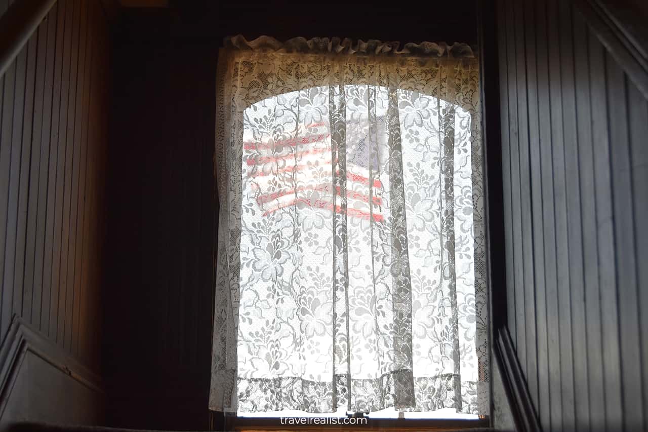 American flag behind behind embroidered lace curtain in Meeker Mansion in Puyallup, Washington, US