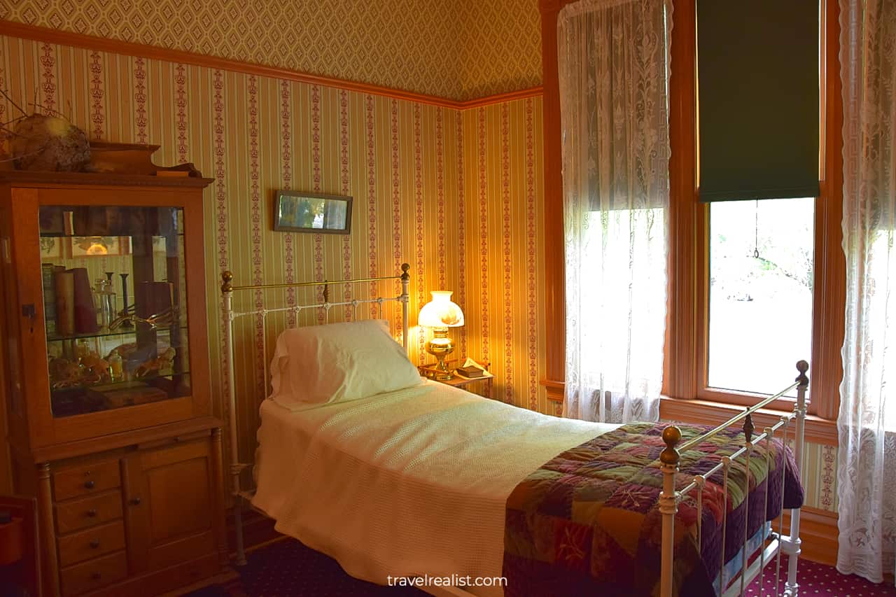 Bed and display cabinet in Ernest Hemingway Birthplace Museum, Oak Park, Illinois, US