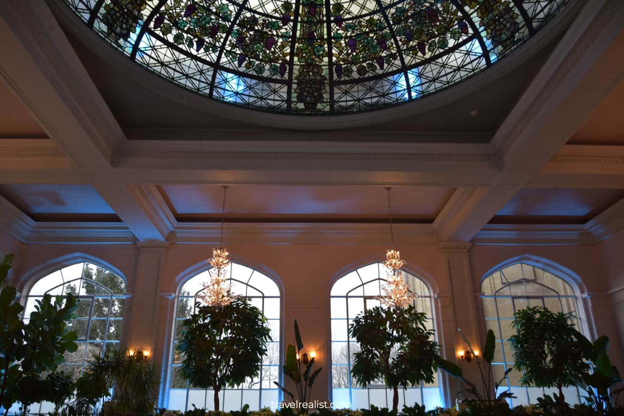Plants and stained glass ceiling in Conservatory in Casa Loma mansion in Toronto, Ontario, Canada